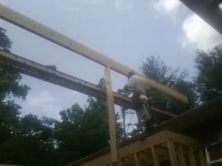 Carpenter setting a ridge beam over a new addition frame — Ice Dam Removal by Roofing Brothers in Clinton Township