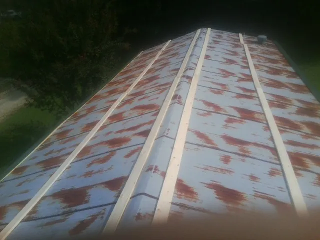 Rusted metal roof panels with new wood purlins before replacement — Storm Damage Roof Repair in Clinton Township by Roofing Brothers