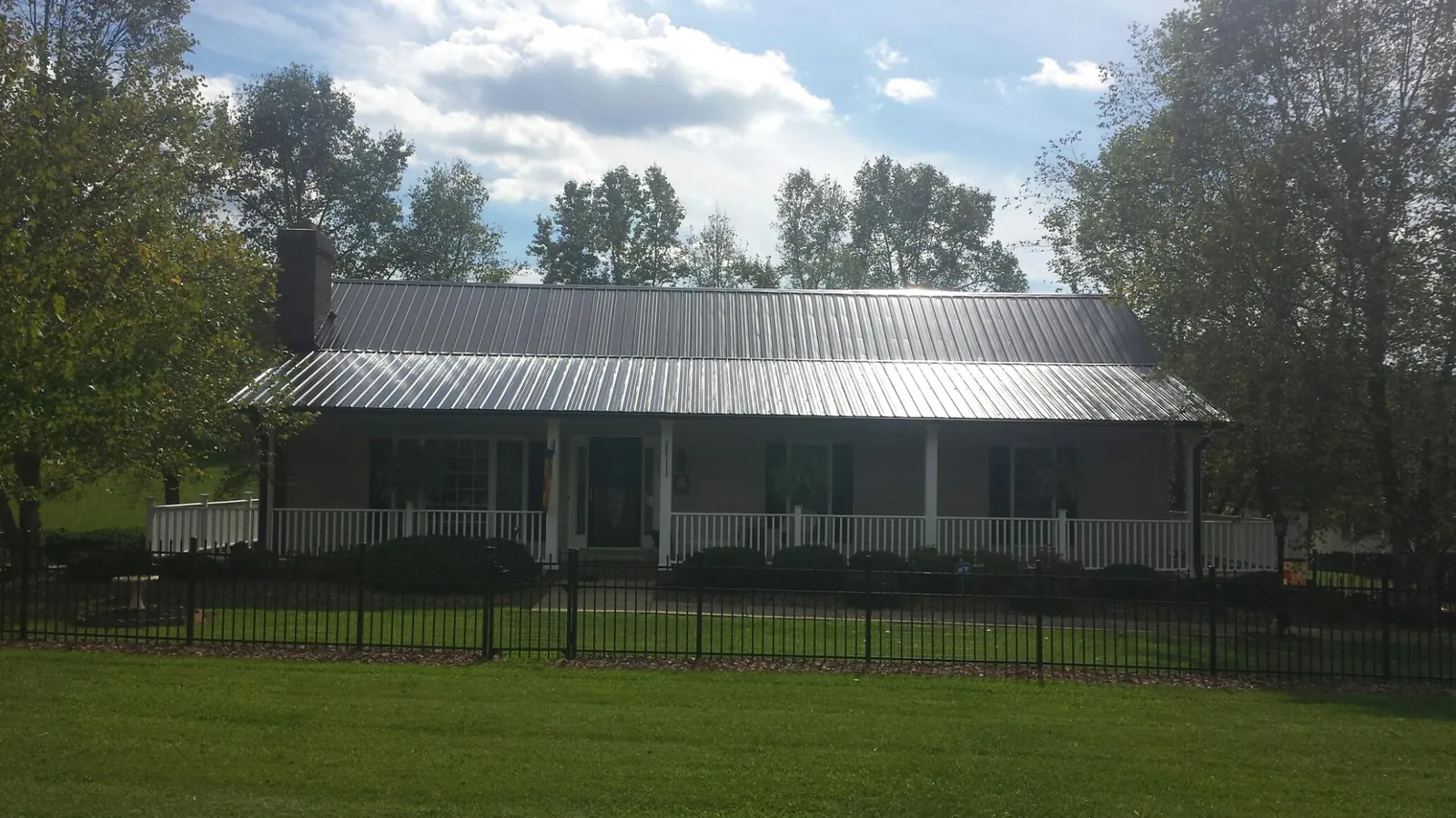 Gray metal roof on a brick ranch with a full width front porch — Gutter Guard Installation work by our crew in Clinton Township