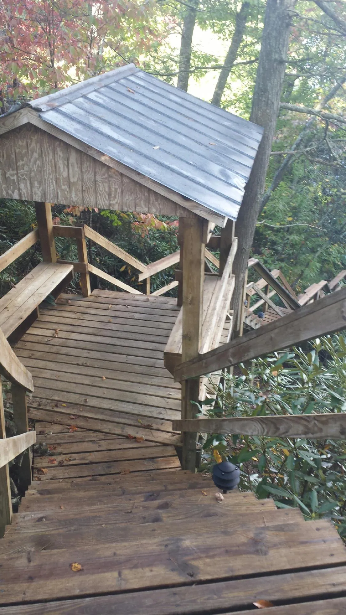Metal roofed shelter over wooden steps on a wooded walkway — Skylight Repair & Installation work by our crew in Clinton Township