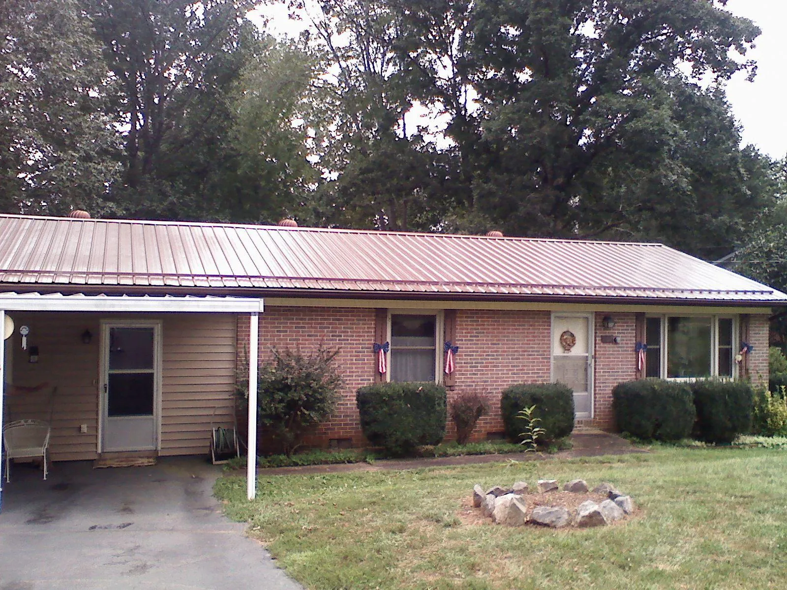 Bronze metal roof and carport on a brick ranch home — Roof Repair work by our crew in Clinton Township